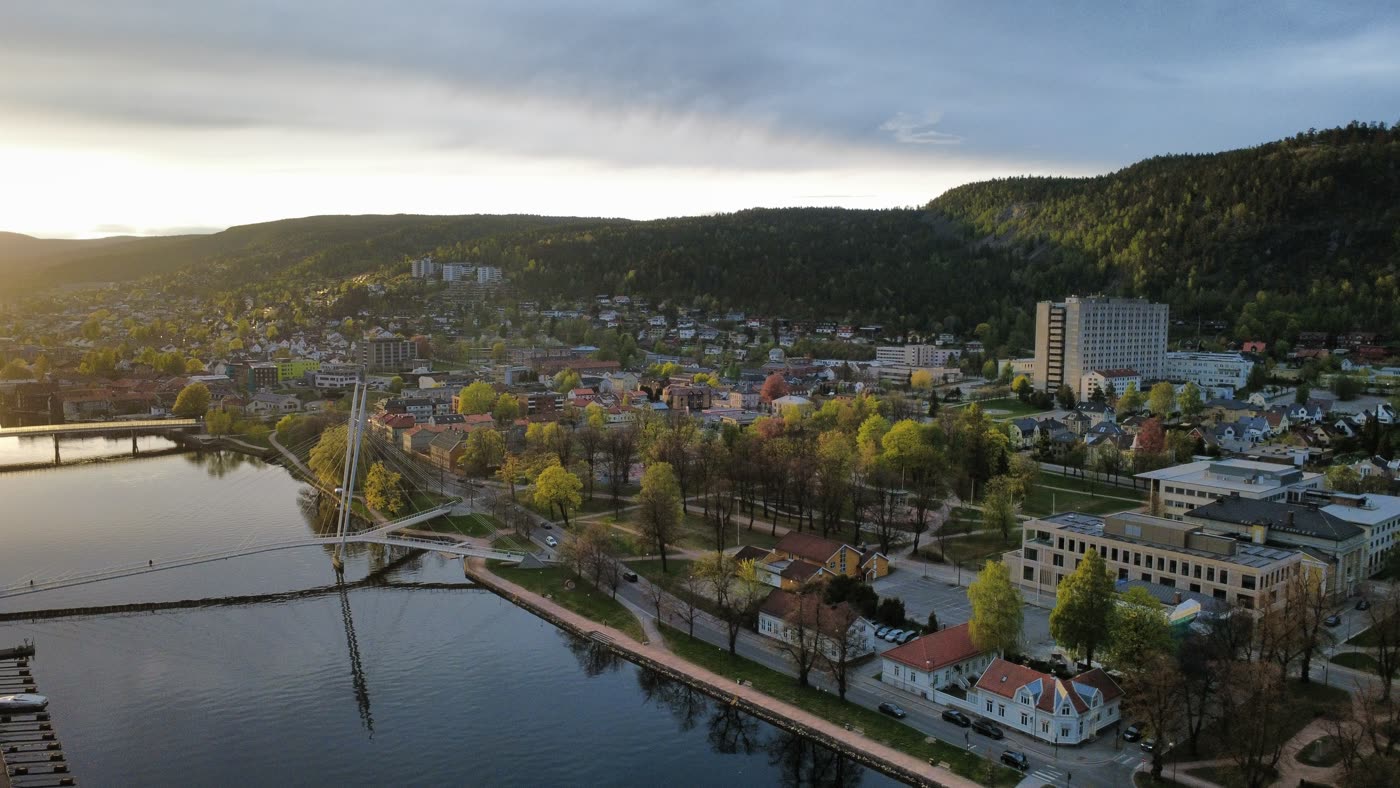 Luftfoto av by og gangbru ved vatnet